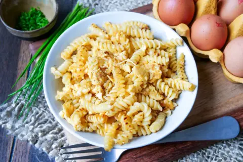 Fusilli-Nudeln mit Rührei, garniert mit Schnittlauch und Pfeffer. Ein einfaches, aber leckeres Gericht: Nudeln mit Ei.