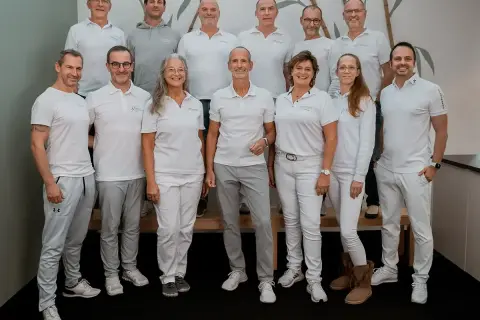 Teamfoto von Liebscher & Bracht. Die meisten tragen weiße Poloshirts und graue Hosen. Keine negativen Erfahrungen hier, nur ein motiviertes Team!