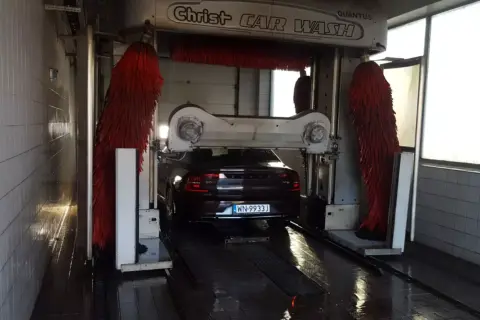 Samochód wjeżdża do myjni automatycznej. Czas dowiedzieć się, jak umyć samochód, by lśnił czystością!