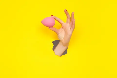 Mano con beauty blender rosa, un modo semplice per capire come pulire le beauty blender.