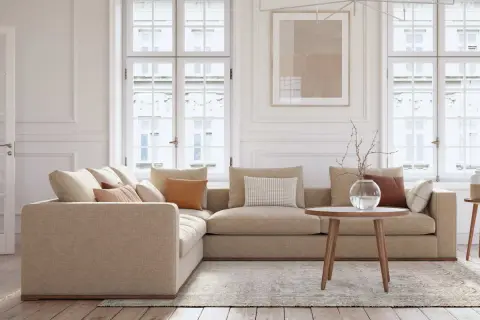 En ljus och luftig salong med en bekväm hörsoffa i beige tyg, perfekt för vardagsbruk tack vare sin höga martindale skala.