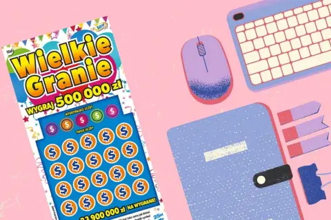 Zdrapka "Wielkie Granie" z szansą na 500 000 zł. Czy to klucz, jak wygrac w zdrapki? Obok klawiatura, myszka i notatnik.