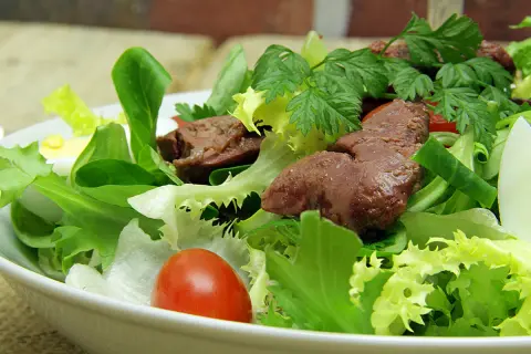 Salade de foies de volaille avec laitue, tomates cerises, œuf dur et persil.