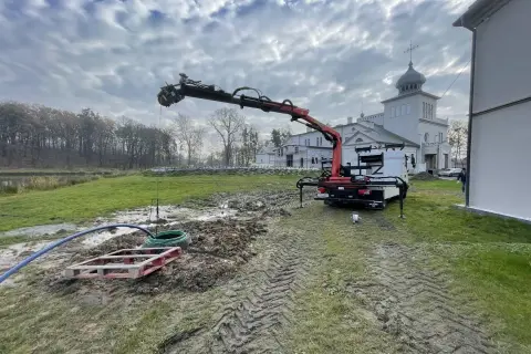 Dźwig z HDS pracuje przy studni, zapewniając własne ujęcie wody dla zabytkowego budynku.