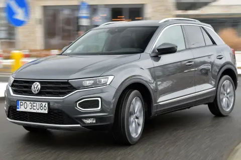 Szary Volkswagen T-Roc w ruchu miejskim. Wiele osób szuka volkswagen t-roc opinie, by podjąć decyzję o zakupie.
