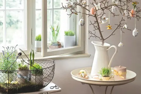 Osterdeko-Ideen: Ein Zweig mit Ostereiern und Frühlingsgrün am Fenster. Ab wann kann man diese Deko aufstellen?