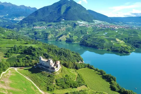 Castello di Tione, vigneti e lago in Val di Non. Un panorama mozzafiato, ideale per scoprire cosa vedere in questa valle incantevole.