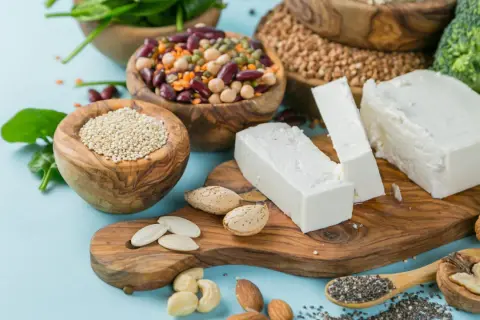 Vielfalt an vegetarischen Proteinquellen: Quinoa, Hülsenfrüchte, Tofu, Nüsse, Samen und Brokkoli.