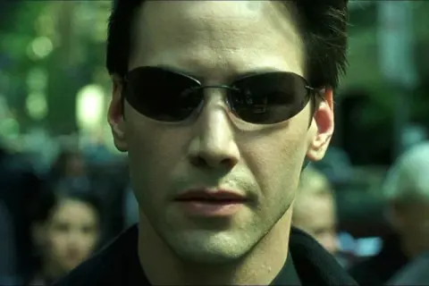 Keanu Reeves w okularach, ikona kina science-fiction. Jego role w filmach takich jak Matrix na zawsze zmieniły gatunek.