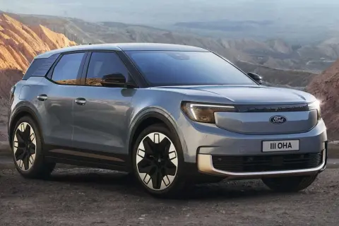 Nowy Ford Explorer EV w szarym kolorze, zaparkowany na tle górskiego krajobrazu.