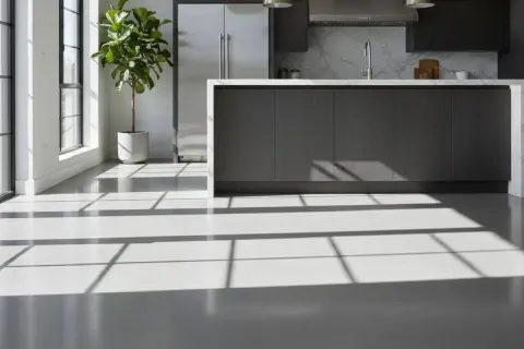 Luminosi pavimenti resina interni in una cucina moderna, con riflessi di luce dalle finestre che creano un gioco di ombre sul pavimento.