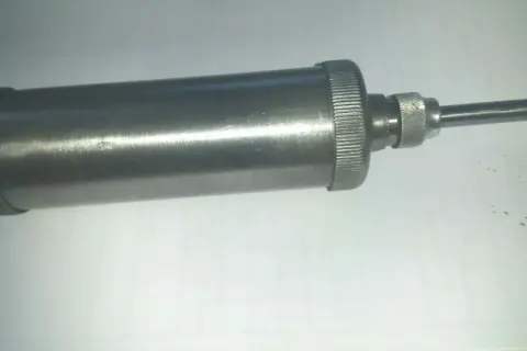 Metallische Handfettpresse mit gerändeltem Griff und Auslauf, ein Beispiel für verschiedene Schmiernippel Arten.