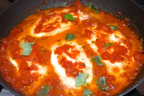 Una succulenta pizzaiola con mozzarella filante, cotta in padella con pomodoro e basilico fresco.