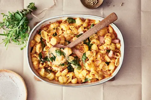 Enkel lyxig middag: krämig pasta med spenat och skinka i ugnsform, redo att serveras.