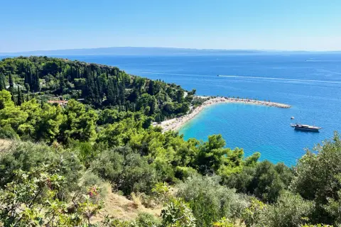 Widok na zatokę z plażą i łodzią. Wspaniałe **Split, Chorwacja atrakcje** przyciągają turystów.