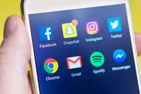 Ekran smartfona z ikonami aplikacji: Facebook, Snapchat, Instagram, Twitter, Chrome, Gmail, Spotify, Messenger. Dowiedz się, jak wyłączyć status aktywności na Messengerze.