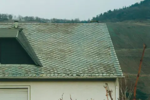 Dachziegel mit schuppenartiger Struktur, die auf Asbest hinweisen könnten. Vorsicht beim Umgang, um asbest dachziegel erkennen zu können.