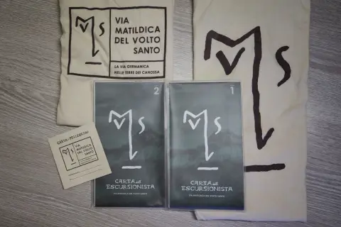 Kit per il pellegrino: sacca, credenziale e due carte dell'escursionista per la Via Matildica del Volto Santo.