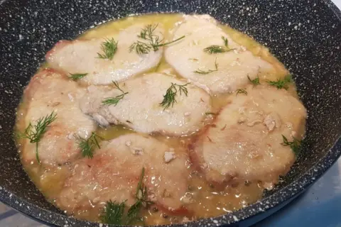 Scaloppine di maiale in padella con un sughetto dorato e finocchietto fresco.