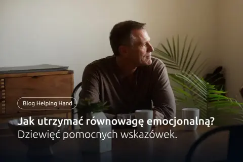 Mężczyzna siedzi przy stole, myśląc o tym, jak osiągnąć homeostazę psychologiczną. Na stole stoją kubki i roślina.