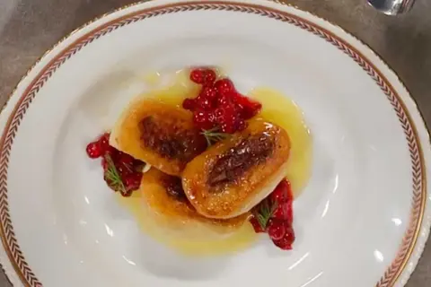 Tre gyllene kroppkakor serveras med lingon och en ljus sås. Ett vackert recept på kroppkakor!