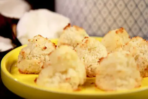 En gul tallrik med nybakade kokostoppar. Perfekt för dig som söker ett enkelt kokostoppar recept.