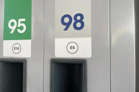 Dwa dystrybutory paliwa: jeden z zielonym oznaczeniem 95 E10, drugi z niebieskim 98 E5.