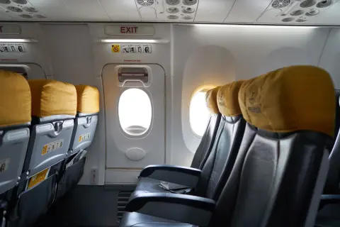 Puste siedzenia w samolocie b737 z żółtymi zagłówkami i oknami.