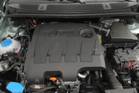 Silnik 1.6 TDI z widocznym logo TDI na pokrywie. Widać zbiornik płynu chłodniczego i elementy układu dolotowego.