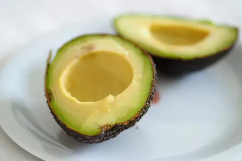 Dwa połówki awokado na talerzu, idealne do guacamole.