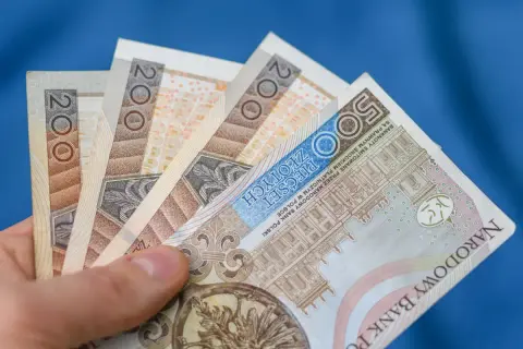 Dłoń trzyma polskie banknoty 200 zł i 500 zł. Chcesz wiedzieć, jak wypłacić pieniądze z funduszu inwestycyjnego Santander?