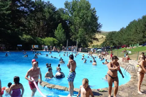 Gente disfrutando de un día soleado en la piscina de la panera Segovia.