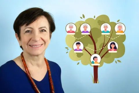 Une femme souriante à côté d'un arbre généalogique illustrant ses origines.