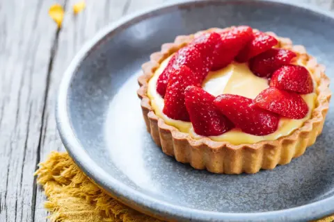 Tarte aux fraises sur pâte brisée, garnie d'une crème pâtissière onctueuse et de fraises fraîches. Un délice !