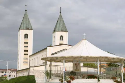 Kościół w Medziugorie z dwoma wieżami i zadaszoną sceną. Miejsce pielgrzymek, gdzie wierni doświadczają objawienia w Medziugorie.