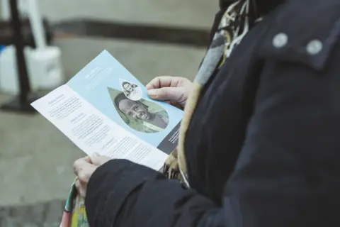 Broschüre einer NGO zeigt lächelndes Kind, das für sauberes Wasser wirbt. Beispiele für NGOs wie diese helfen, Leben zu verbessern.