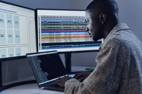 Un développeur analyse des données complexes sur plusieurs écrans, optimisant le code pour le **junit logo**.