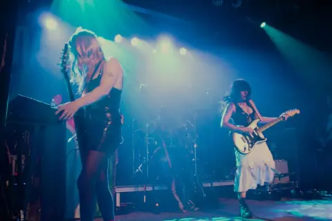 Mannequin Pussy rocks the stage, with one guitarist playing a keyboard and the other shredding a white electric guitar.