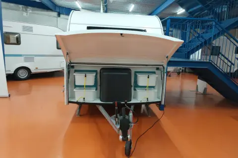 Detalle de la distribución de una furgoneta camper, mostrando compartimentos de almacenamiento y la lanza.