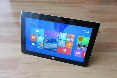 Tablet z interfejsem Windows 8, widok z góry, na drewnianym blacie.