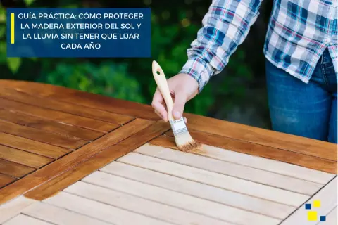 Persona aplica aceite a mesa de madera exterior con brocha. Guía práctica: cómo proteger la madera sin barnizar del sol y la lluvia.
