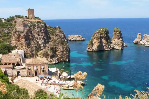 Scogliera con torre a Castellammare del Golfo, mare cristallino e faraglioni.