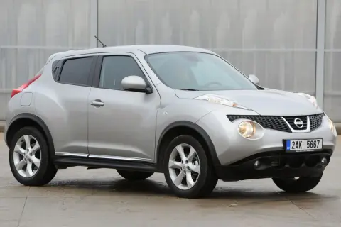 Srebrny Nissan Juke, często chwalony w nissan juke opinie, prezentuje się dynamicznie na tle nowoczesnej architektury.