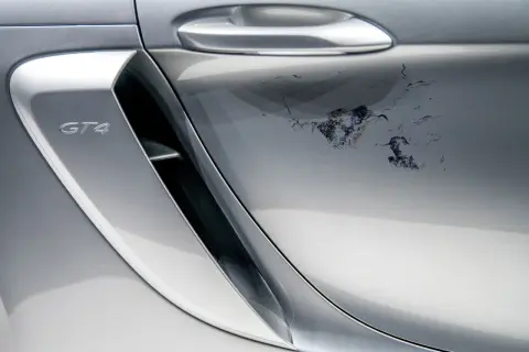 Na srebrnym lakierze Porsche GT4 schodzi lakier bezbarwny, tworząc nieestetyczne plamy. Jak naprawić ten problem?