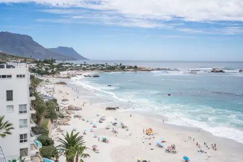 Sonniger Strand in Kapstadt mit vielen Menschen, die entspannen. Die Frage "ist Kapstadt sicher?" scheint hier positiv beantwortet.