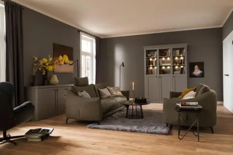 Ein weicher, grauer Teppich liegt unter dem Sofa und dem Couchtisch und schafft eine gemütliche Atmosphäre im Wohnzimmer.