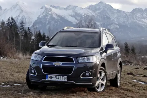 Chevrolet Captiva na tle górskich szczytów. Wiele osób szuka chevrolet captiva opinie, by sprawdzić, czy ten SUV sprawdzi się w trudnym terenie.
