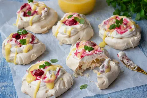 Små pavlovakakor med grädde, hallon och citronkräm. En perfekt liten dessert!