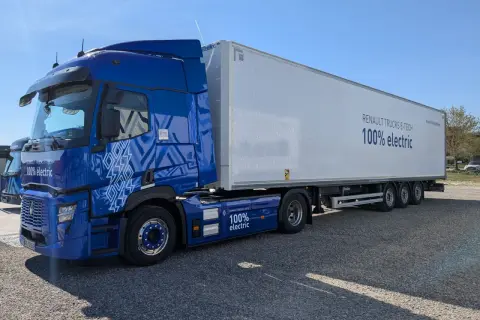 Un camion renault electrique bleu vif, avec une remorque blanche arborant le message "100% electric".
