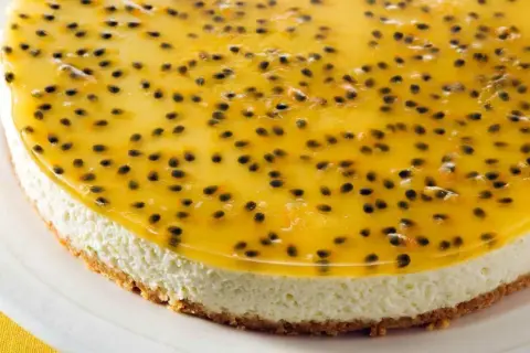 En krämig cheesecake med en krispig botten, toppad med en glansig gelé fylld med passionsfruktens svarta kärnor. En riktig passionsfrukt cheesecake-dröm!